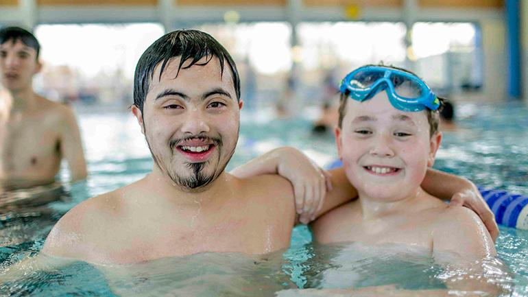 Zwei Jugendliche stehen im Schwimmbecken nebeneinander