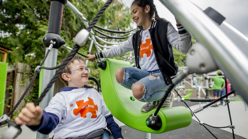 Zwei Kinder auf einem inklusiven Spielplatz.