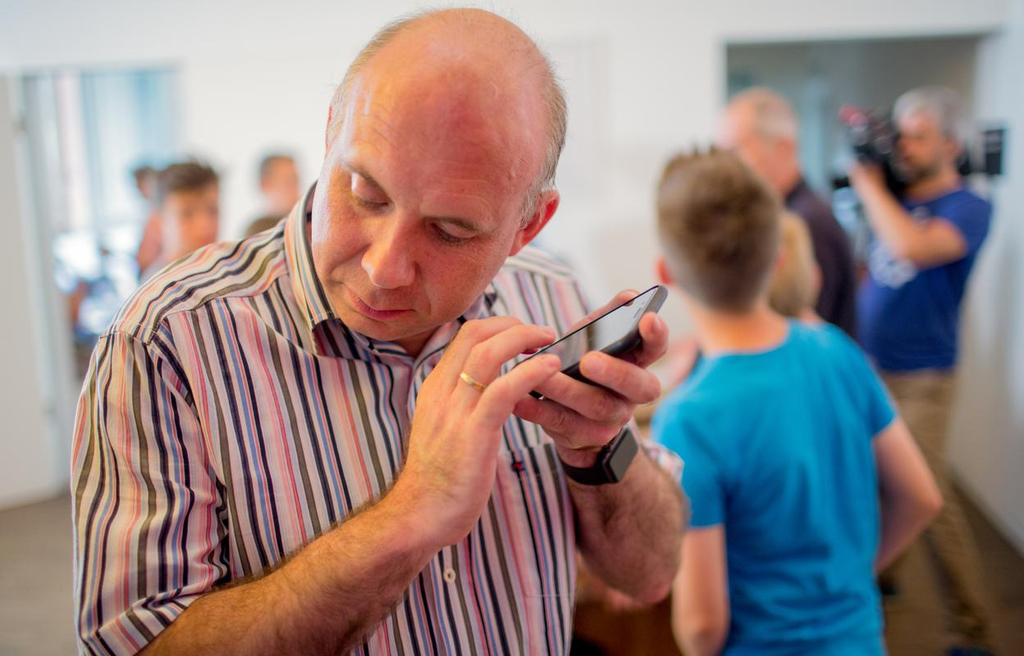 Ein Mann hält sich sein Smartphone ans Ohr. 