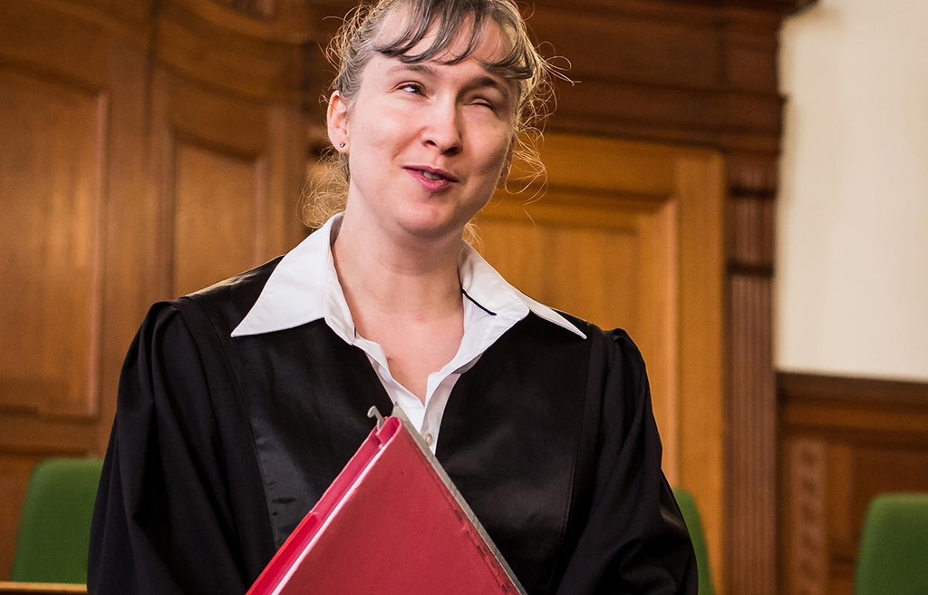 Blinde Rechtsanwältin in Robe im Gerichtssaal