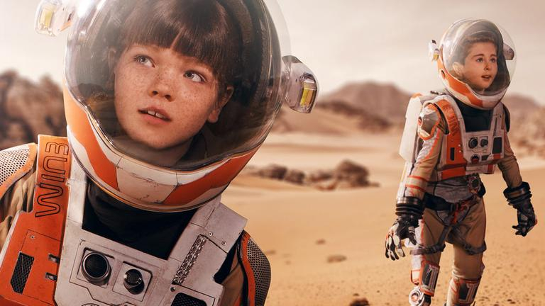Zwei Kinder in Astronautenanzügen auf dem Mars. Ein Kind hat eine Beinprothese.