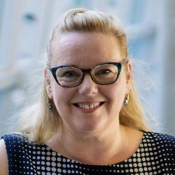 Porträt Kertin Merz-Atalik, Mitte 40, lustiges Lachen, lange blonde Haare zurückgebunden, Retro-Brille Haare