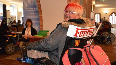 rollstuhlfahrerin dreht ihren kopf und lächelt