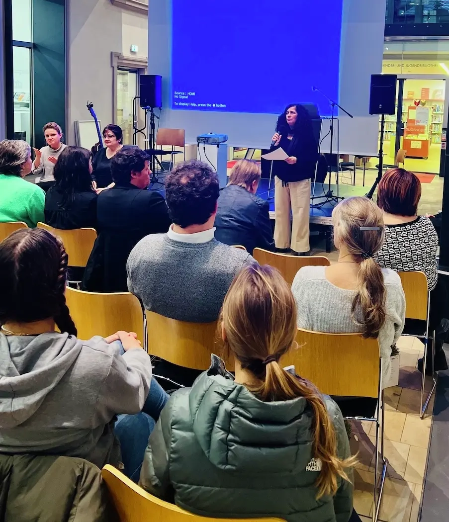 Carolina Zibell spricht vor einer Gruppe von Menschen.