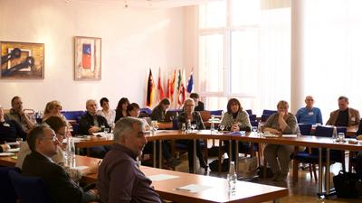 Viele Menschen sitzen an einem Konferenztisch