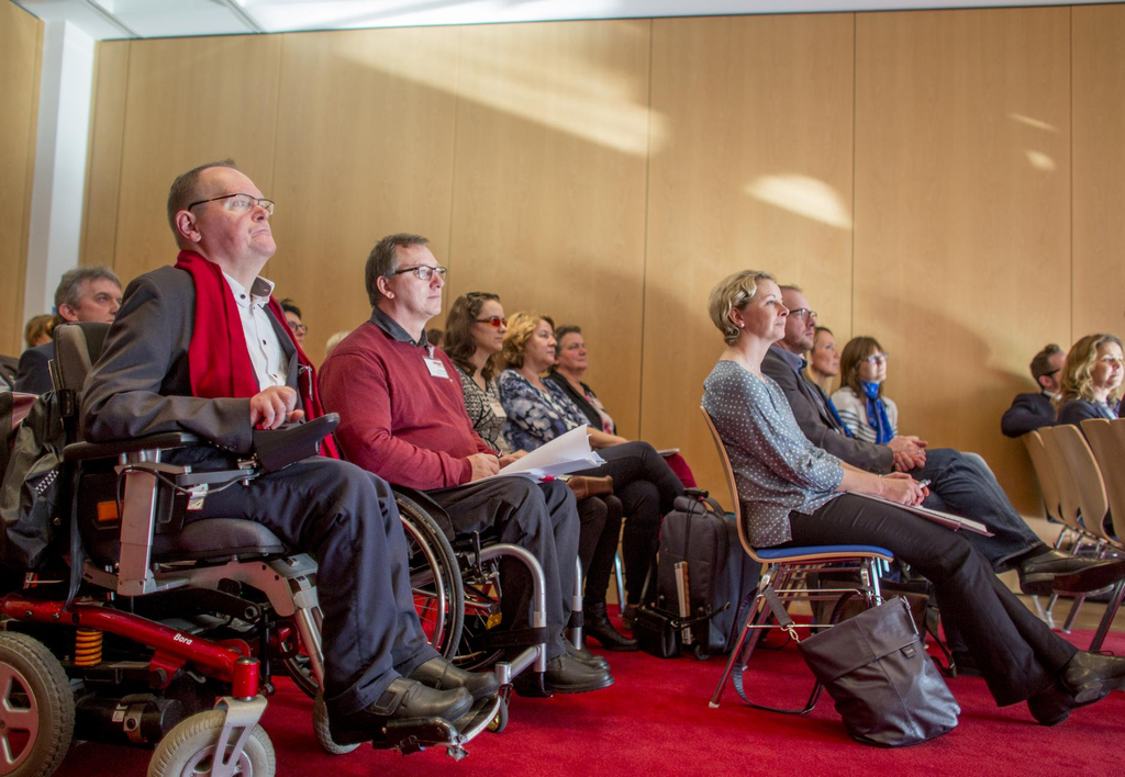 Das Publikum hört interessiert zu.