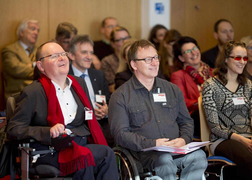 Menschen sitzen im Publikum.