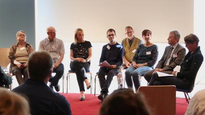 Viele Menschen sitzen zusammen und diskutieren