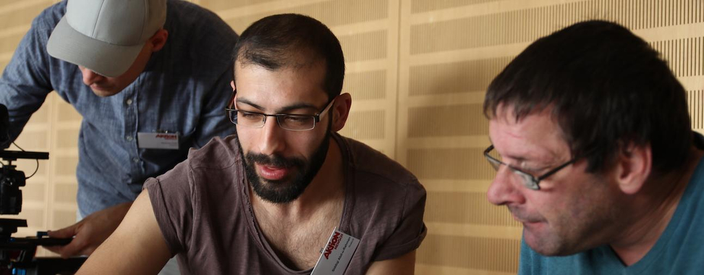 Zwei Männer sitzen an einem Tisch und arbeiten konzentriert