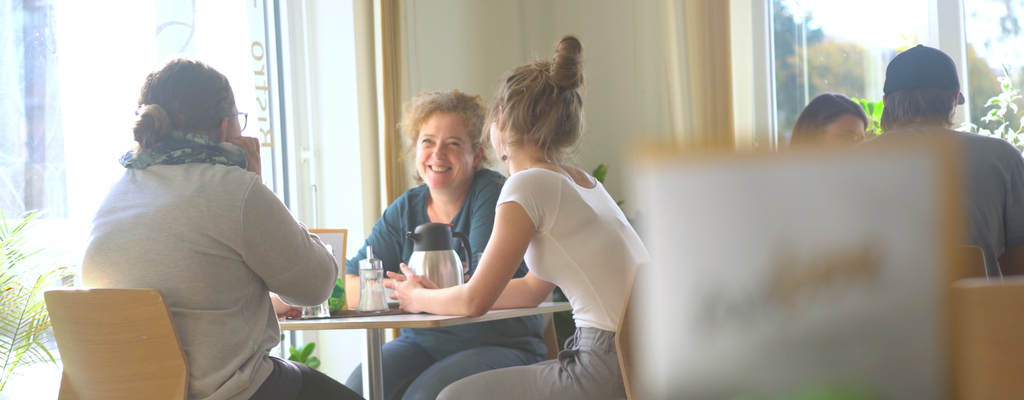 Frauen an einem Tisch unterhalten sich.