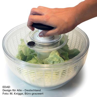 Jemand bedient eine Salatschleuder mit nur einer Hand