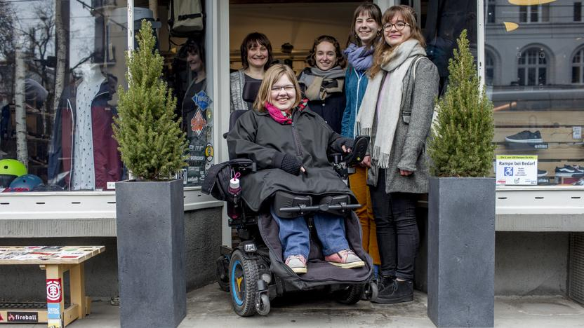 Vor dem Eingang eines Geschäfts ist eine kleine Stufe, an der eine Rampe aus Lego-Steinen ist.