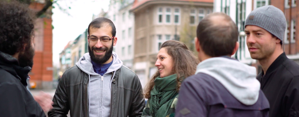 Mehrere Personen, die in einer Gruppe zusammenstehen und lachen.