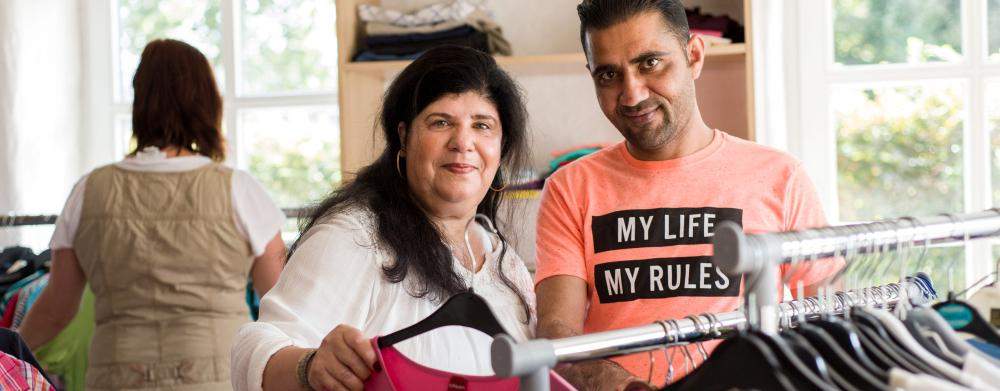 Eine Frau und ein Mann stehen vor einem Kleiderständer