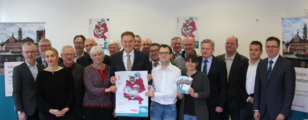 mehrere Menschen halten gemeinsam ein Plakat hoch