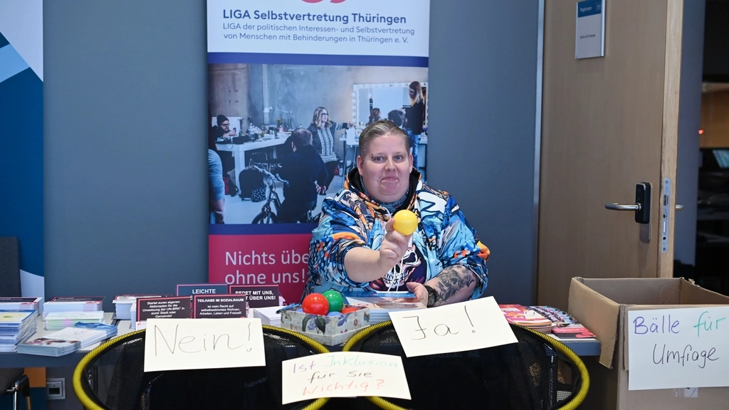 Eine Frau sitzt hinter einem Stand der LIGA Selbstvertretung Thüringen