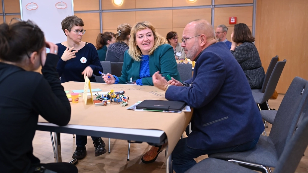 Teilnehmende eines Workshops sitzen an einem Tisch