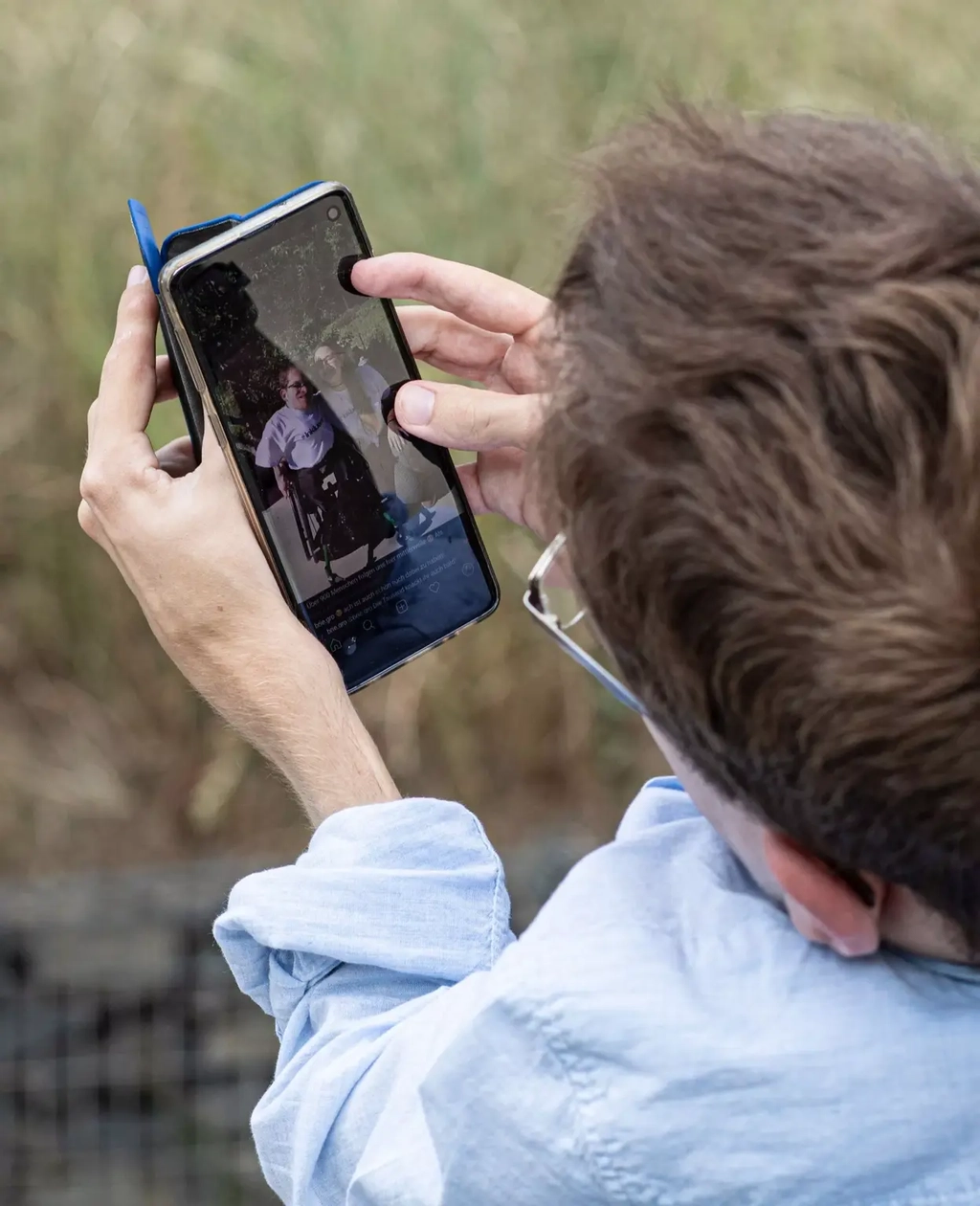 Max begutachtet auf seinem Handy ein Bild von sich und Cristina.
