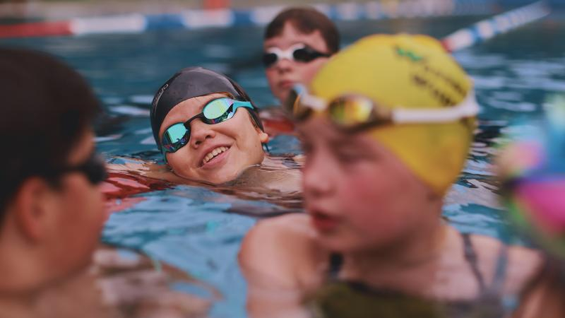 Ein Mädchen schwimmt durch ein Schwimmbecken.