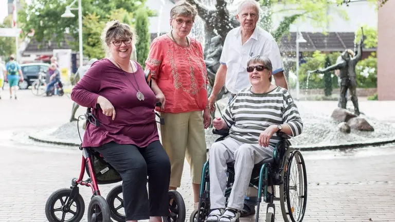 Eine Gruppe von Menschen mit und ohne Behinderung an einem Brunnen in Schneverdingen