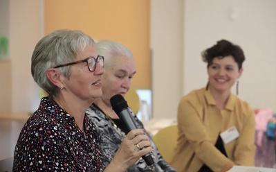 Eine Seniorin spricht auf einer Veranstaltung in der Modellkommune Erlangen