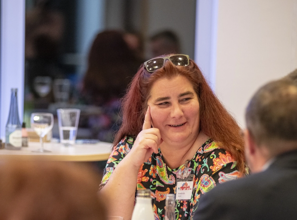 Annette Kob spricht mit einem anderen Gast auf einer Veranstaltung