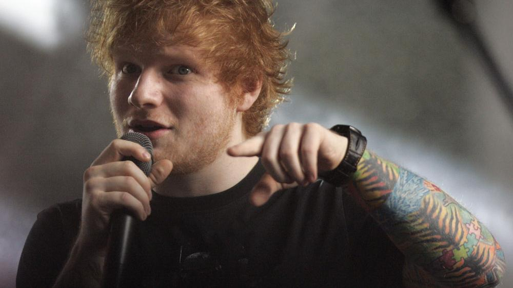 Nahaufnahme von Ed Sheeran, er singt ins Mikro und schaut in die Kamera