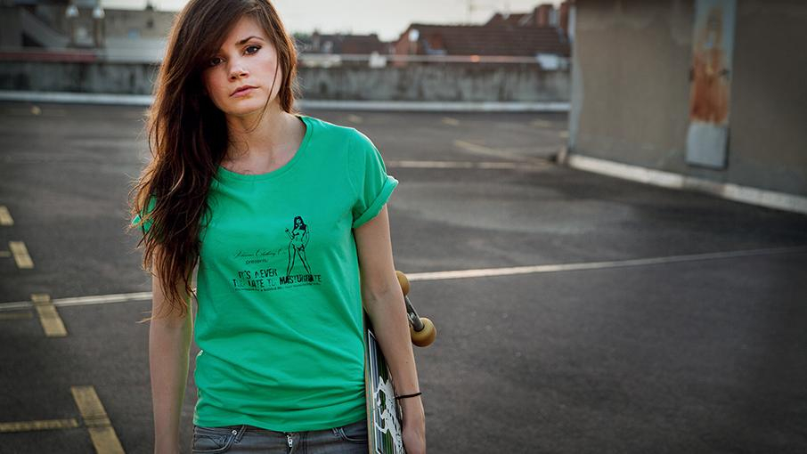 Joyce steht an einer Straße mit Skateboard unterm Arm, Abendstimmung