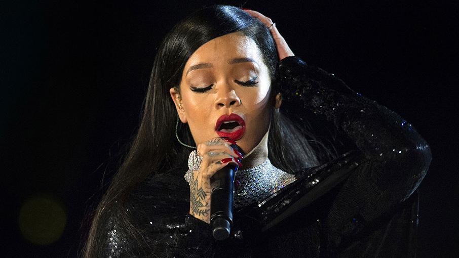 Sängerin Rhianna bei einm Auftritt, sie singt mit geschlossenen Augen ins Mikro