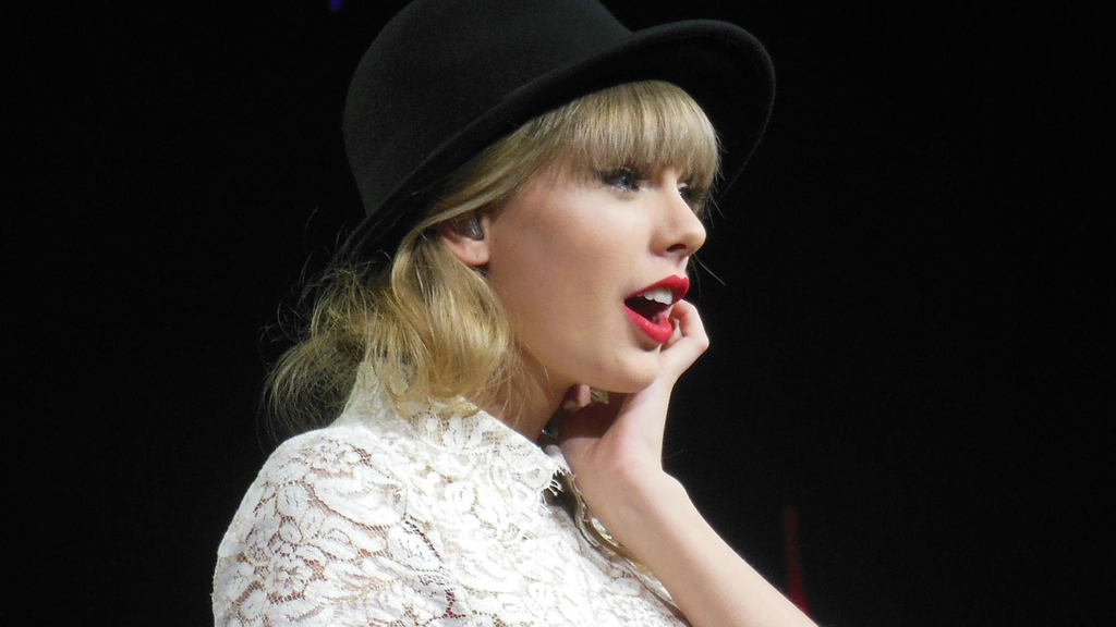 Taylor Swift mit schwarzem Hut und weißer Spitzenbluse