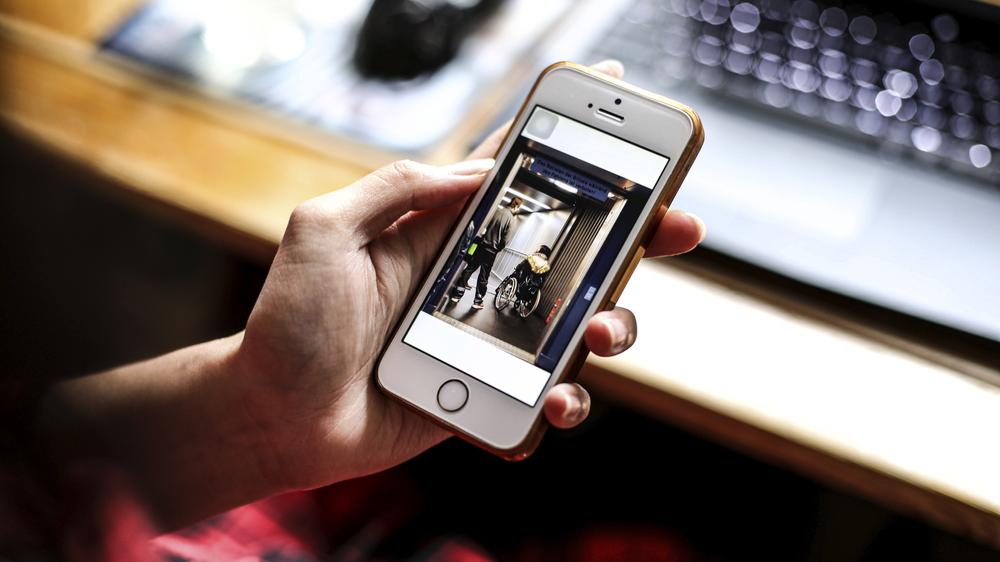 Simone schaut sich auf ihrem Smartphone ein Foto aus ihrem Shooting an.