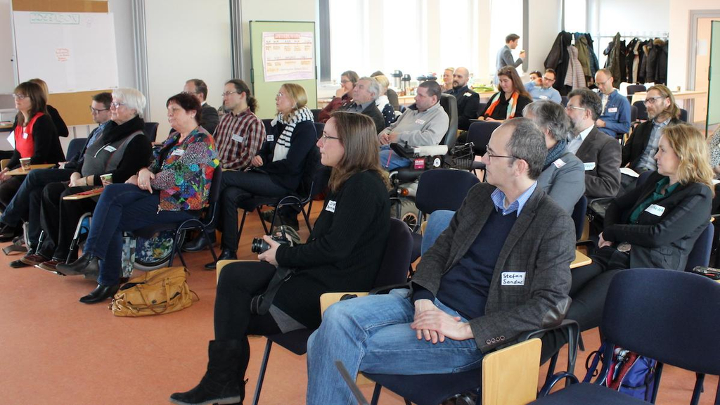 Sitzende Menschen hören angeregt zu