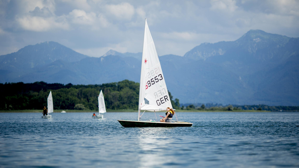 Mehrere Segelboote sind auf dem Chiemsee unterwegs.