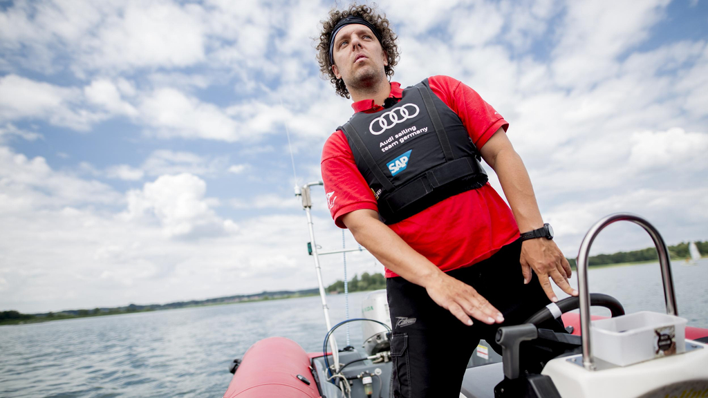 Ein Mann steht am Steuer eines Schlaubootes.