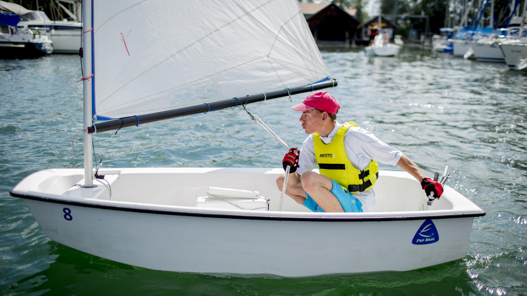 Ein junger Mann in einem Segelboot.