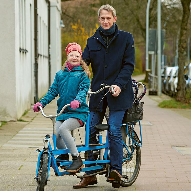 Ein Mann und ein Mädchen auf einem Tandem-Fahrrad