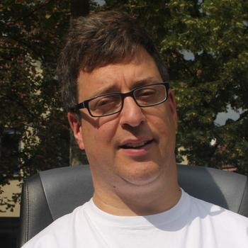 Porträt Simon Maier, Anfang 40, kurze dunkle Haare, Brille