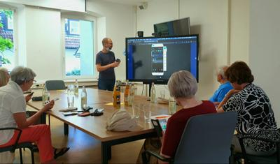 Senior*innen nehmen an einem Smartphone-Kurs in Erlangen teil.