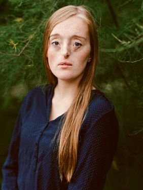 Eine junge Frau mit glattem langem rotblonden Haar. Ihre Augen, Nase und Mund sehen etwas anders aus als gewöhnlich.