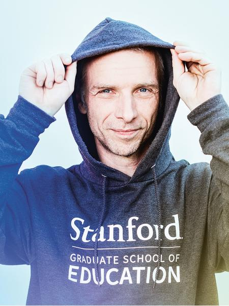 Junger Mann zieht die Kapuze seines Hoodies über den Kopf