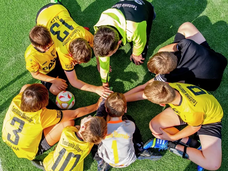Die Spieler des Fußballvereins Teutonia Überruhr legen ihre Hände im Kreis übereinander