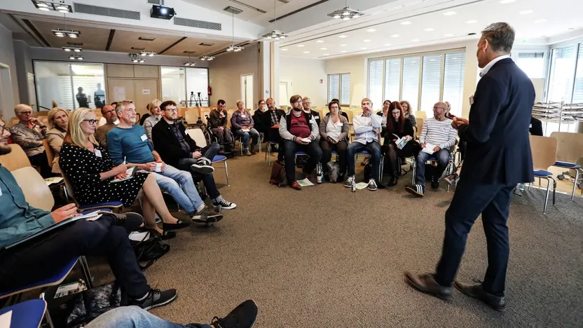 Ein Mann hält einen Vortrag vor einer Gruppe von Menschen