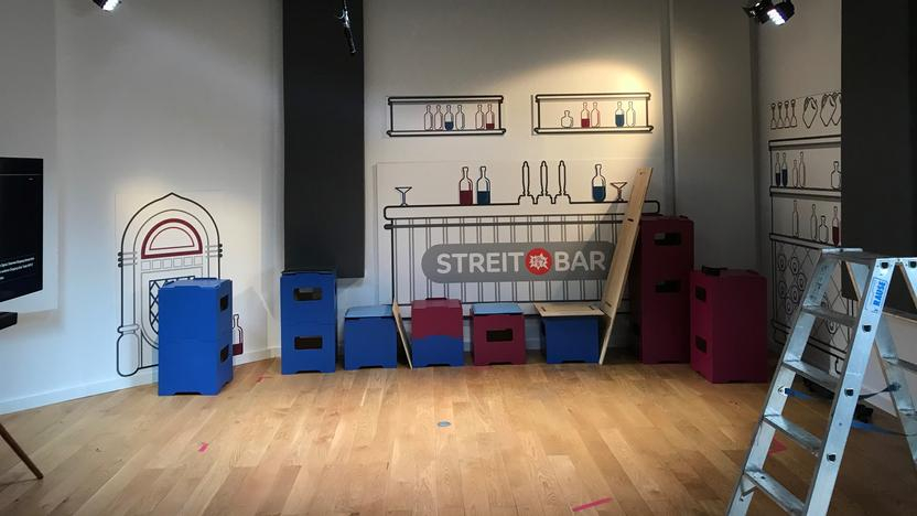 Ein leeres Filmstudio mit Hockern, an der Wand das Streitbar-Logo