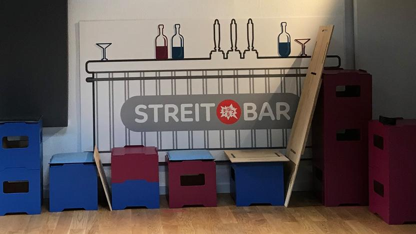 Ein leeres Filmstudio mit Hockern, an der Wand das Streitbar-Logo