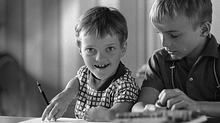 Zwei Jungen, einer davon mit Behinderung, hinter der Schulbank.
