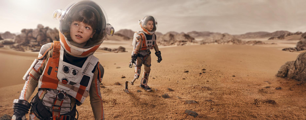 Zwei Kinder in Raumanzügen laufen über die Oberfläche des Mars. Eines der Kinder hat eine Beinprothese.