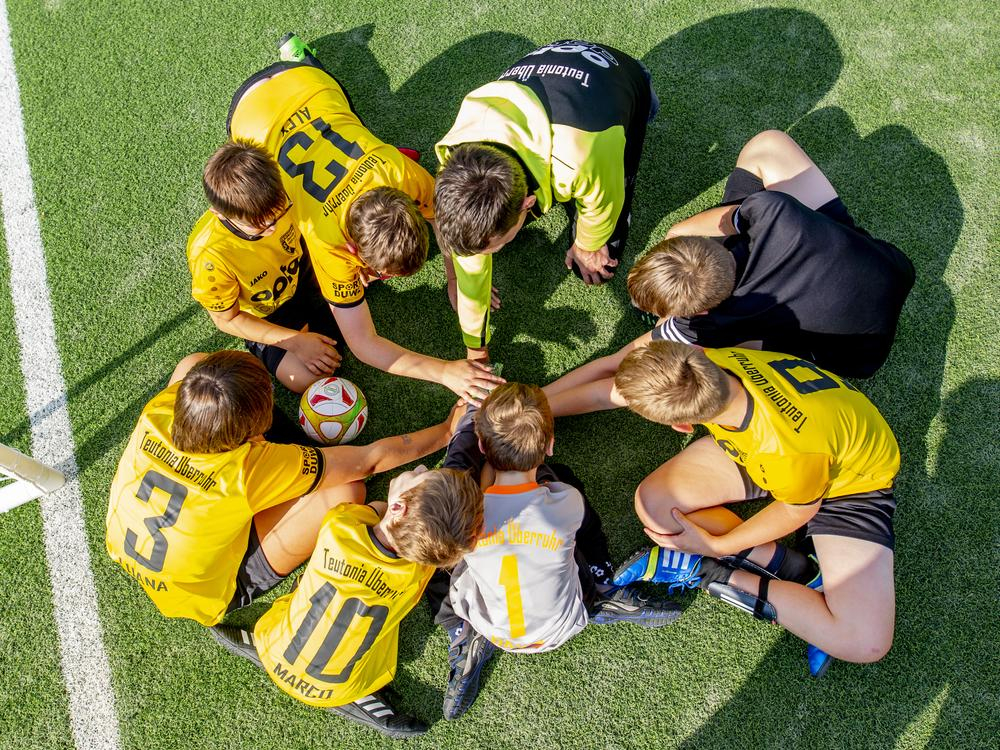 Die Spieler des Fußballvereins Teutonia Überruhr legen ihre Hände im Kreis übereinander