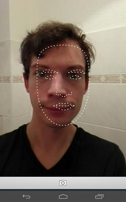 Foto im Handydisplay eines jungen Mannes mit ernstem Blick. Die Konturen seines Gesichts sind mit einer gestrichelten Linie nachgezogen.