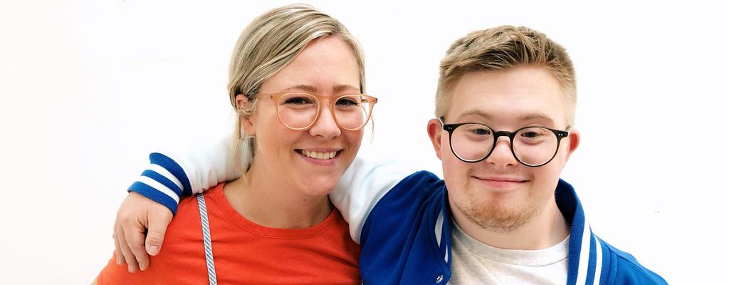 Die beiden Geschwister Tabea und Marian lächeln Arm in Arm in die Kamera.