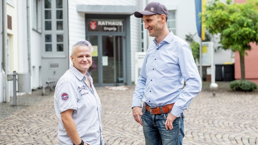 Zwei Personen stehen vor dem Rathaus in Nieder-Olm.